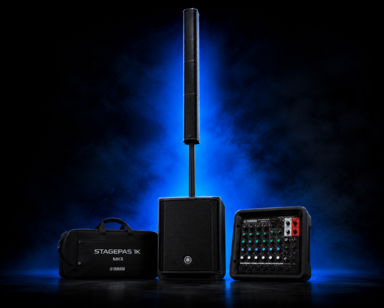 Yamaha STAGEPAS 1K MKII column PA system with powered subwoofer, integrated digital mixer, and line array speaker, photographed in a professional studio with a dark background and subtle blue lighting. Premium portable column sound system for DJs, live bands, weddings, churches, corporate events, conferences, karaoke, and professional live sound reinforcement.